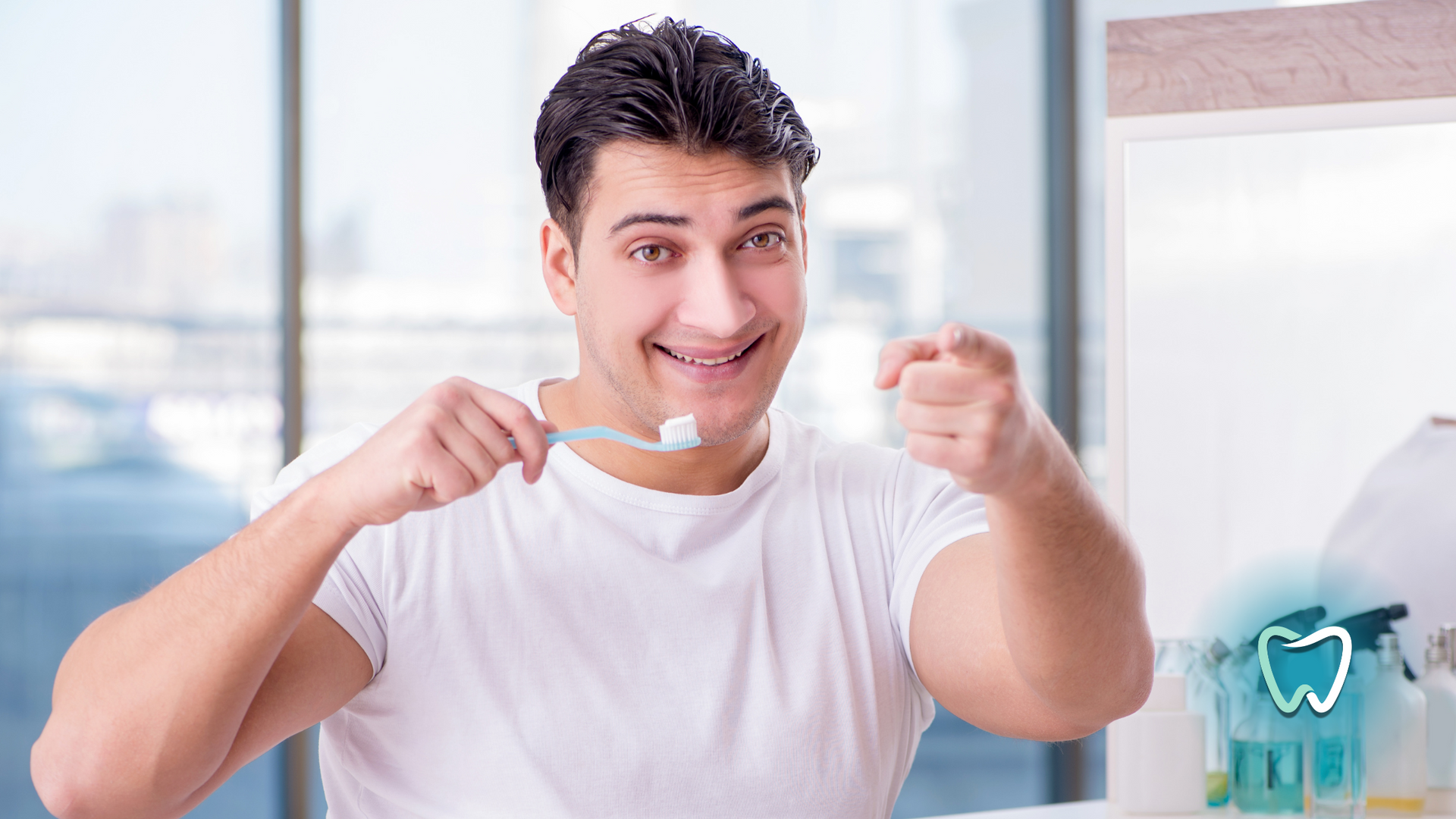 A man is brushing his teeth in front of a mirror and pointing at the camera.
