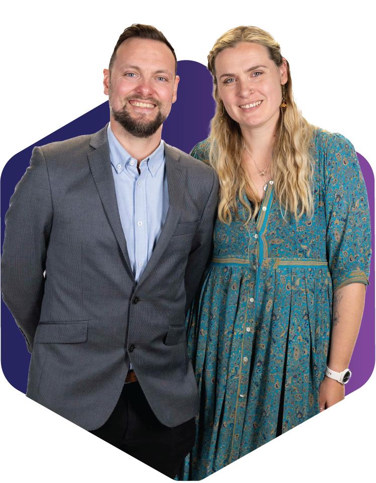 Two people standing together, smiling, with a colorful hexagon background.