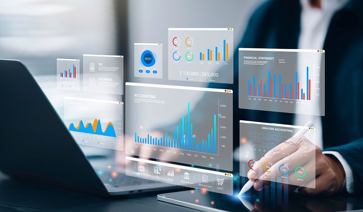 Businessperson using a laptop with floating analytics dashboards and charts in a modern office