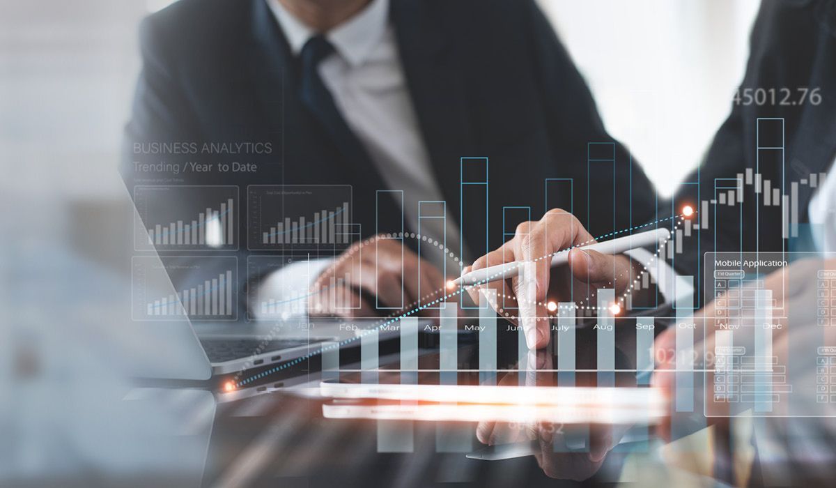 Business professionals analyzing financial data on transparent charts and graphs in an office setting