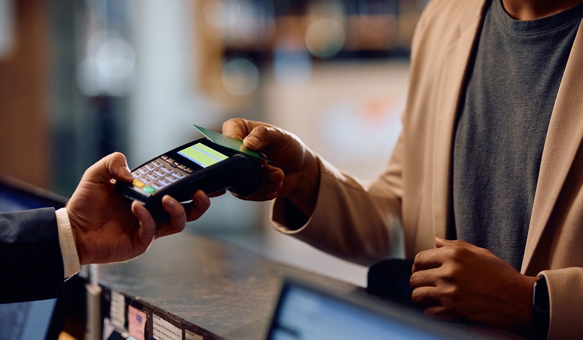 Handing over a contactless payment card at a checkout counter