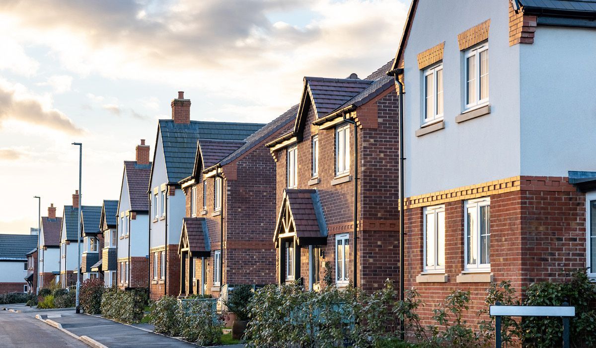 Row of modern brick houses on a quiet residential street at dusk