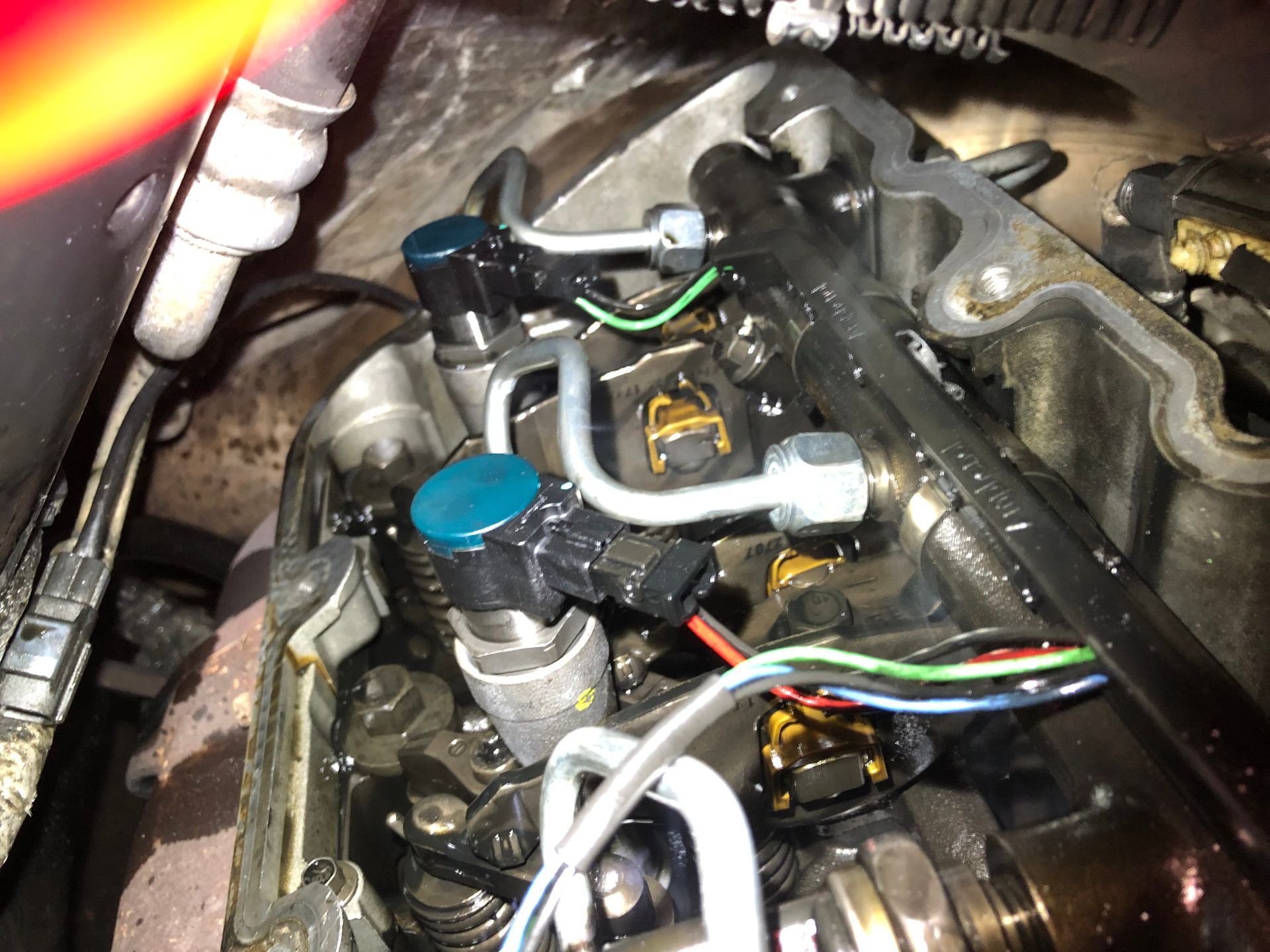 A close up of a car engine with wires coming out of it