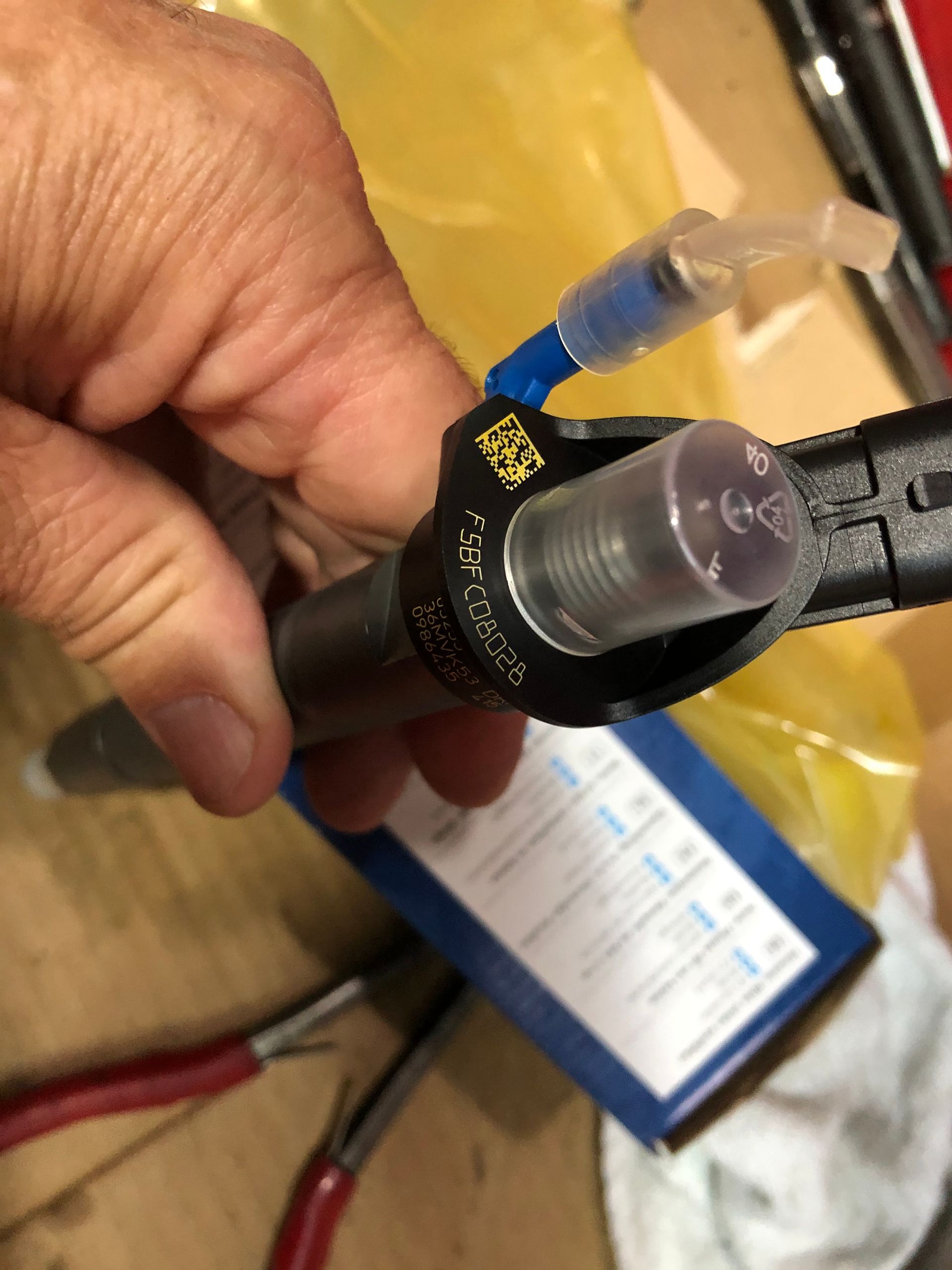 A close up of a person holding a fuel injector