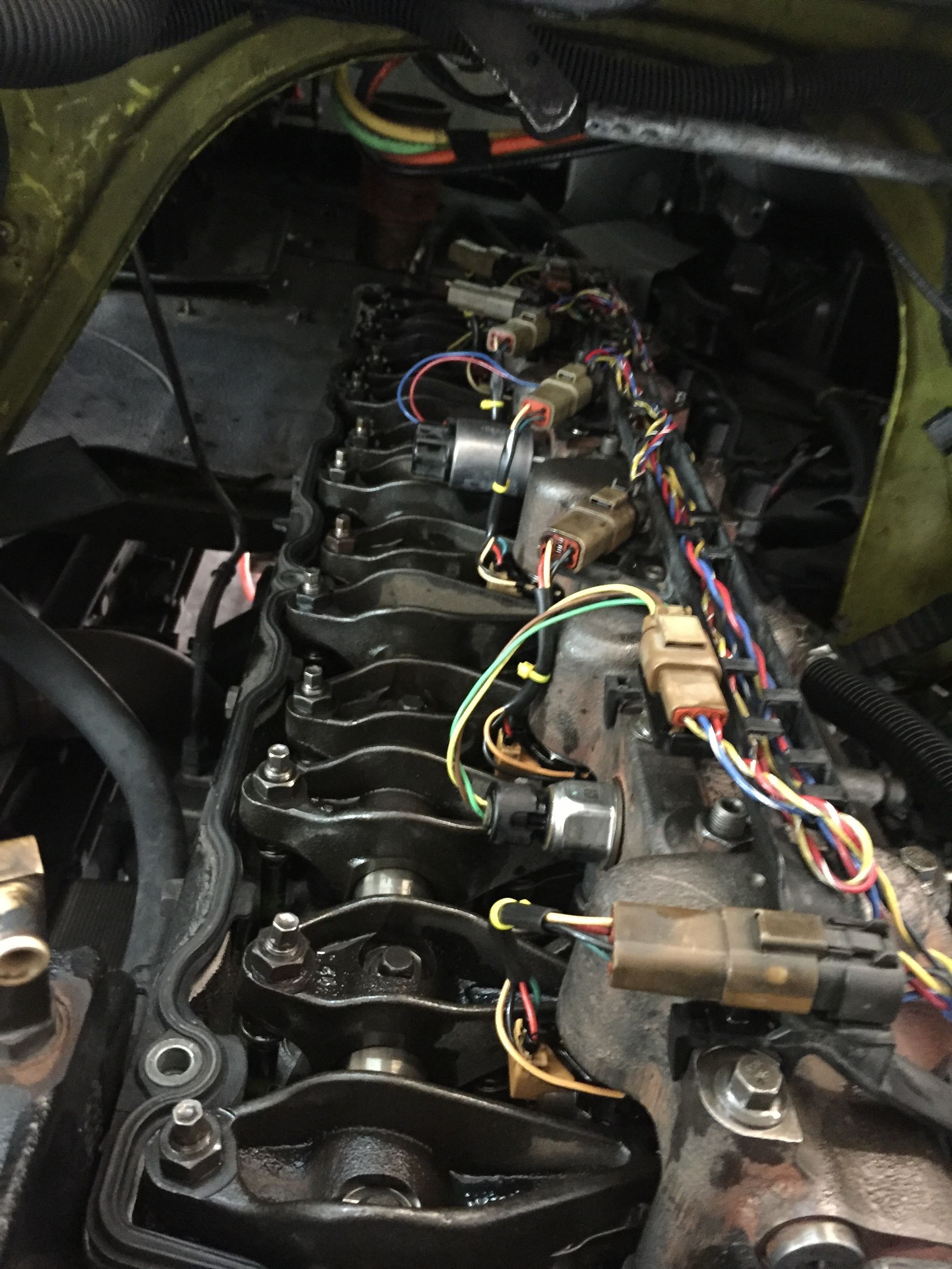 A close up of a car engine with a lot of wires coming out of it.