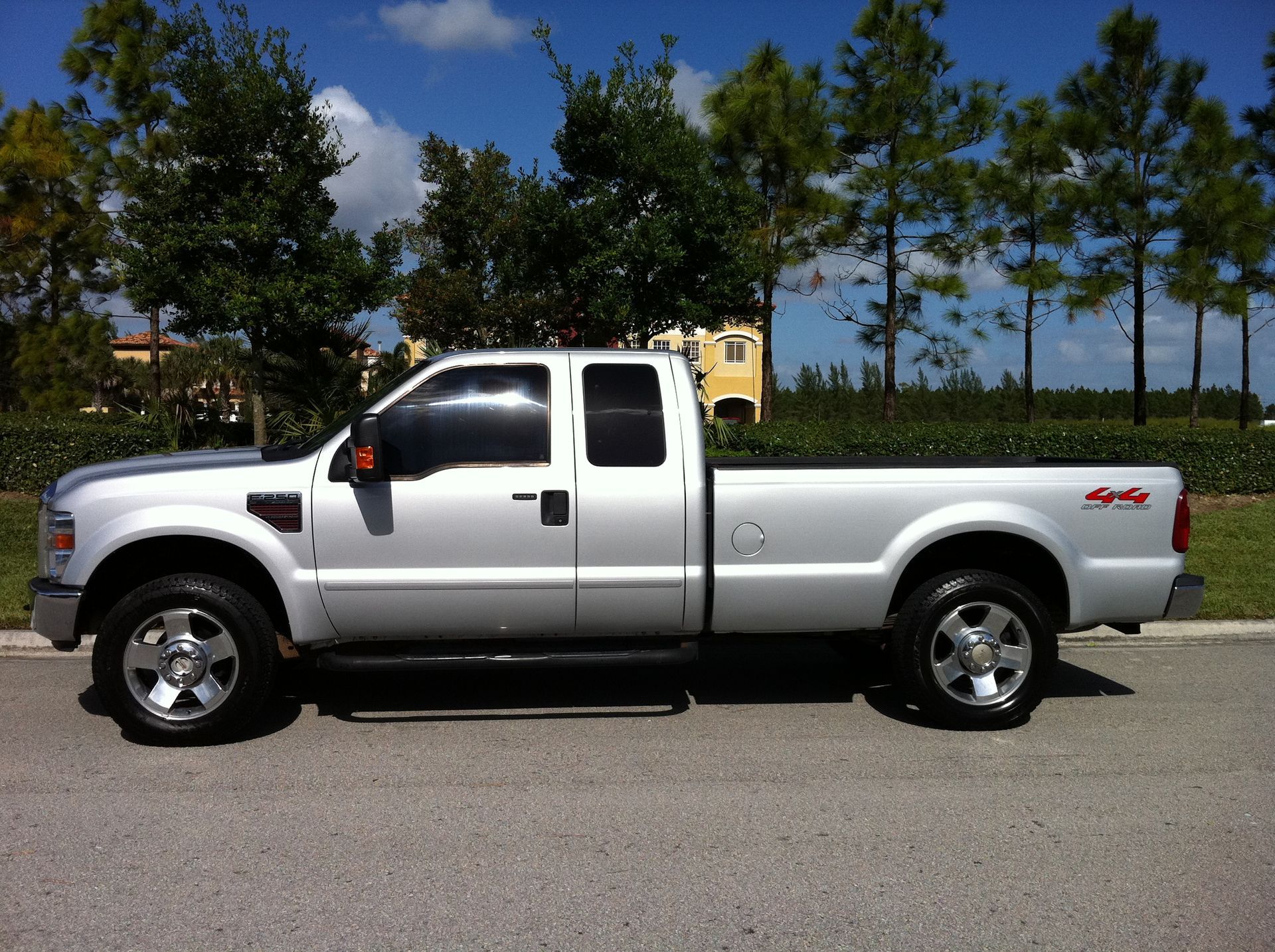 A silver truck is parked on the side of the road