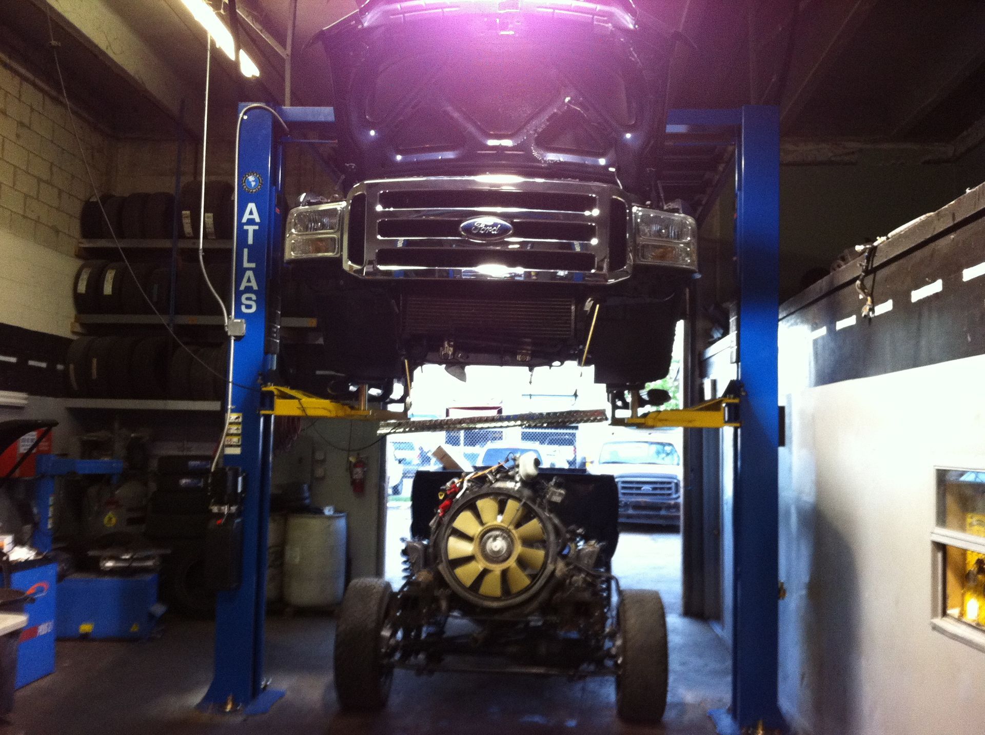 A ford truck is on a lift in a garage