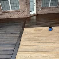 A wooden deck partially stained dark brown next to an unstained, light-colored section, with a blue cup on the deck.