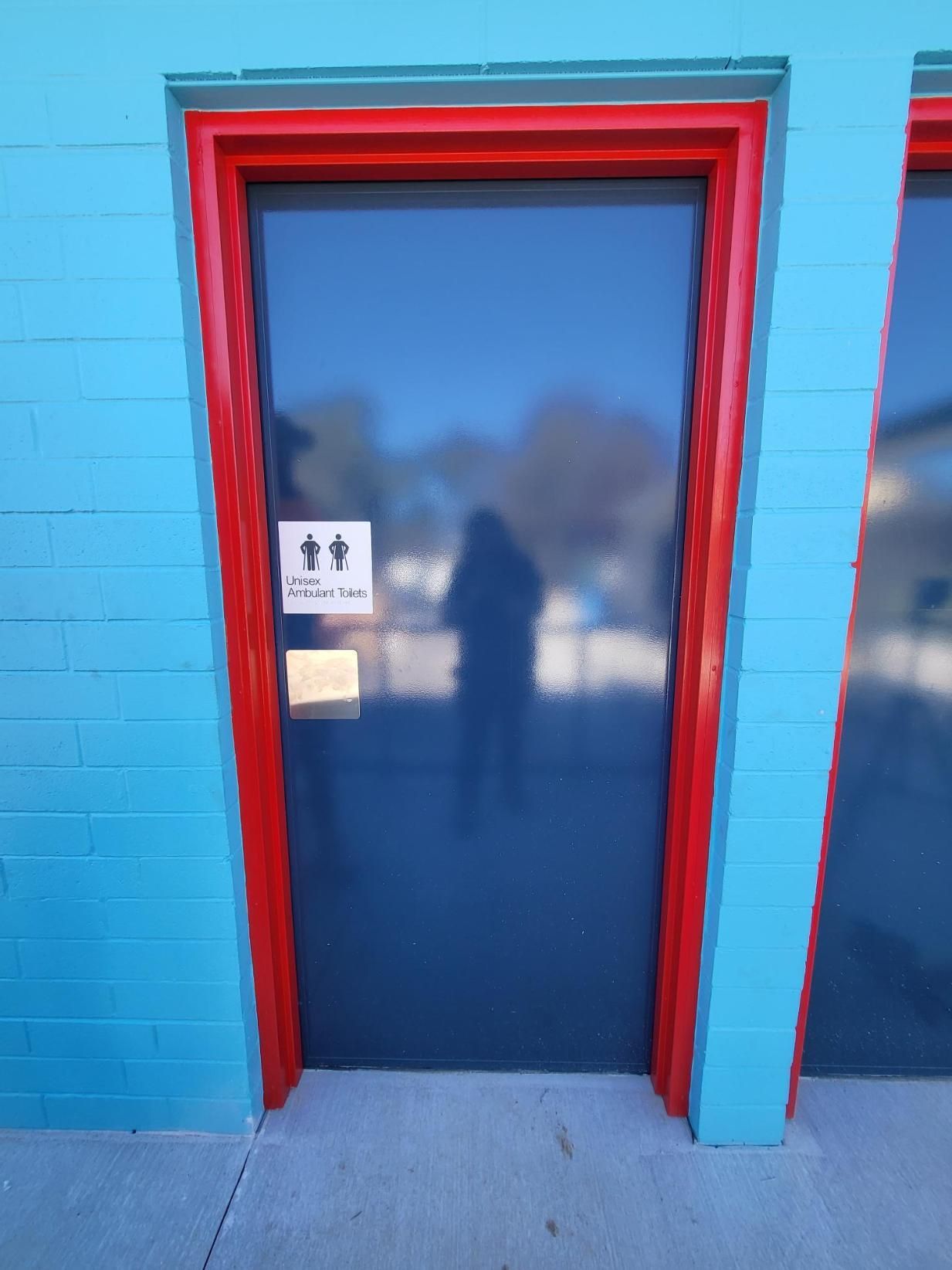 A Blue Brick Building With a Black Door and a Red Trim — Signworld In Mitchell, ACT