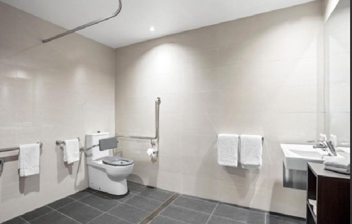 An accessible bathroom with a toilet , sink , and shower.