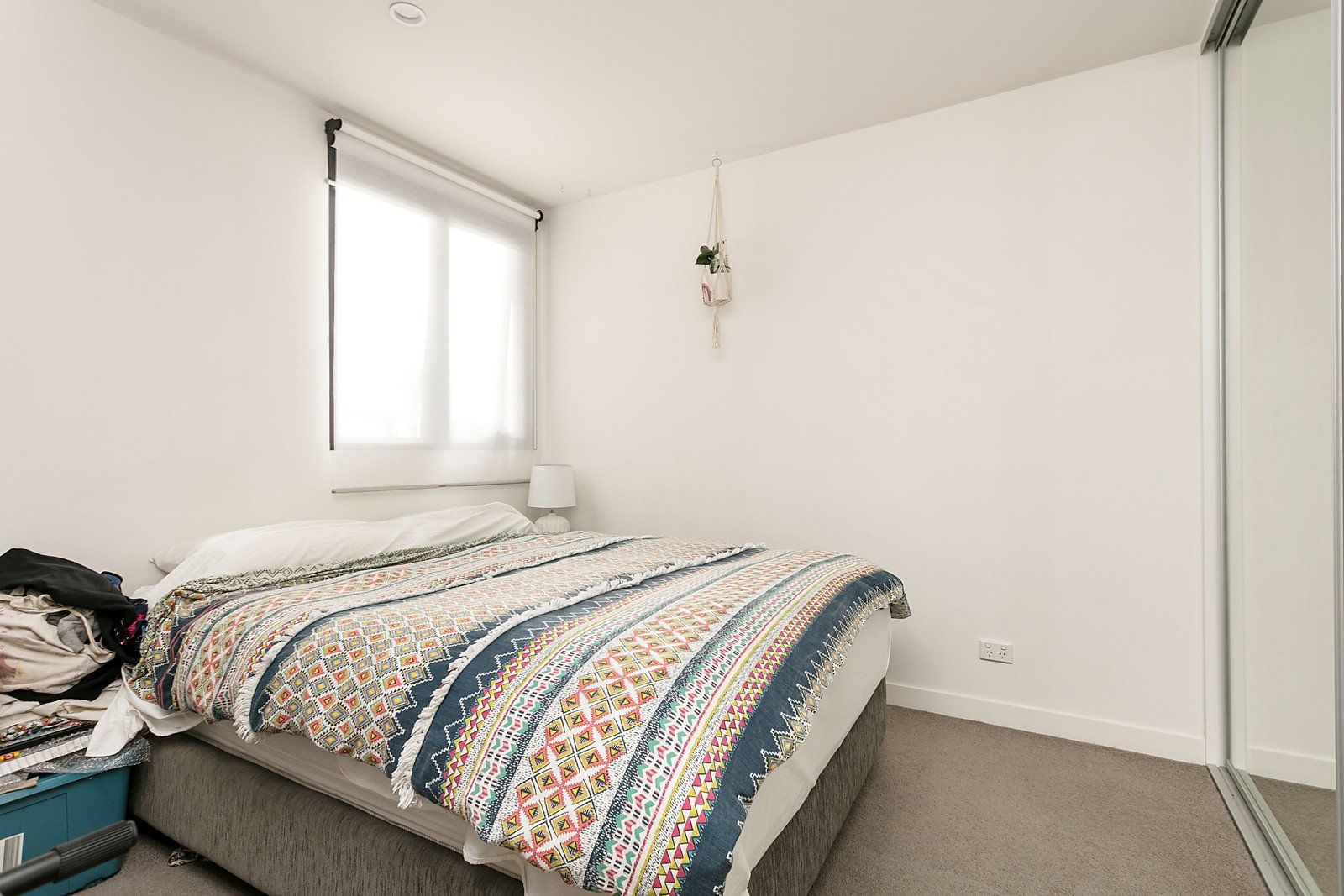 A bedroom with a bed and a mirror.
