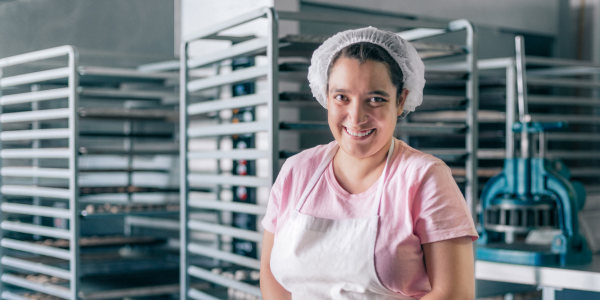 Young woman with disability wearing apron in a bakery