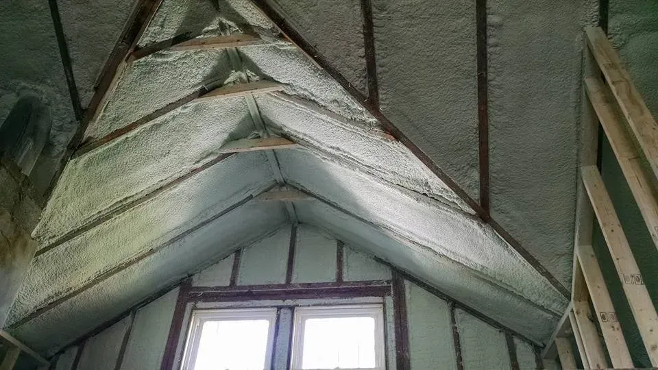 A room with a vaulted ceiling and a window.