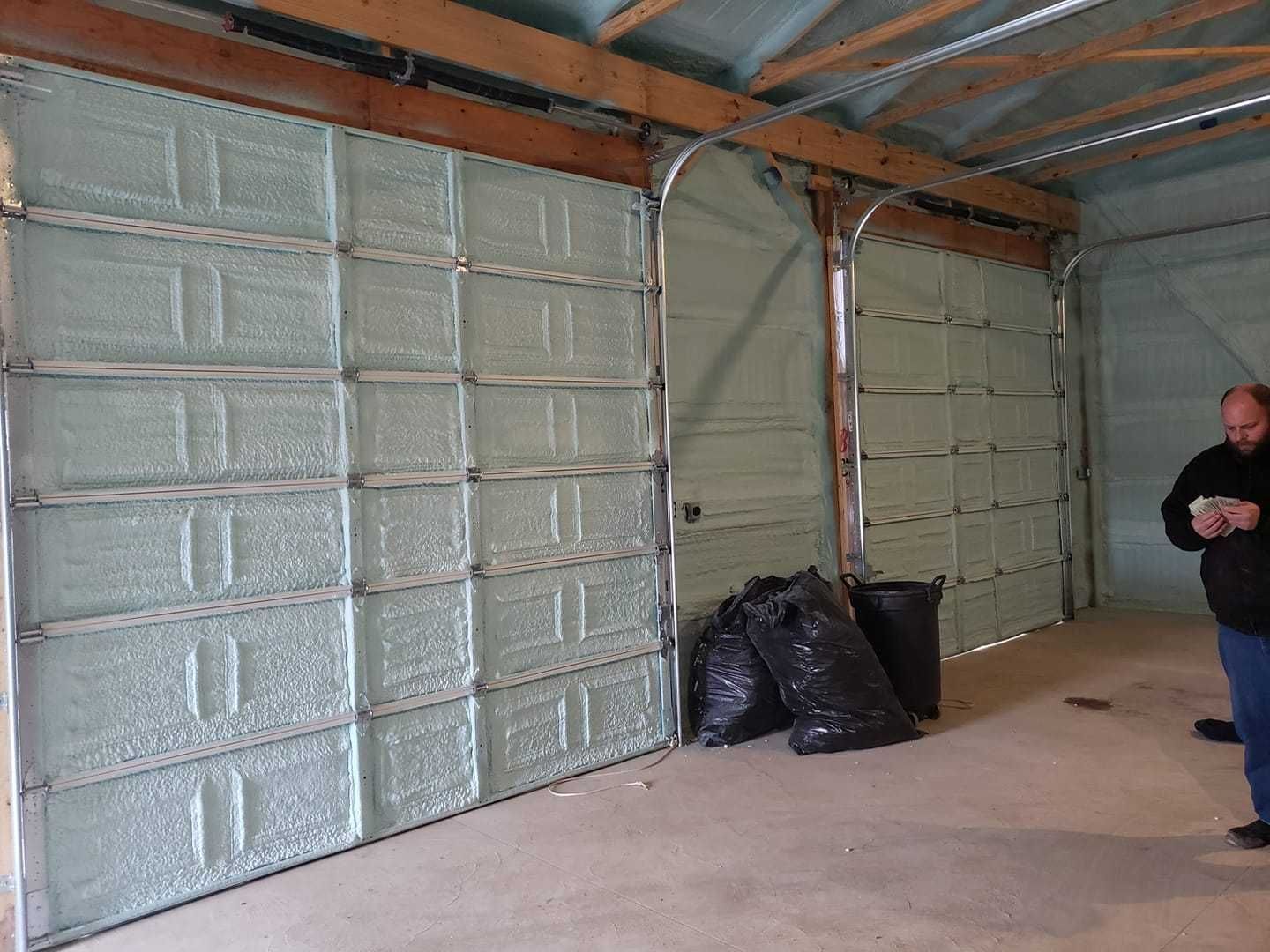 A man is standing in a garage with a lot of garage doors.