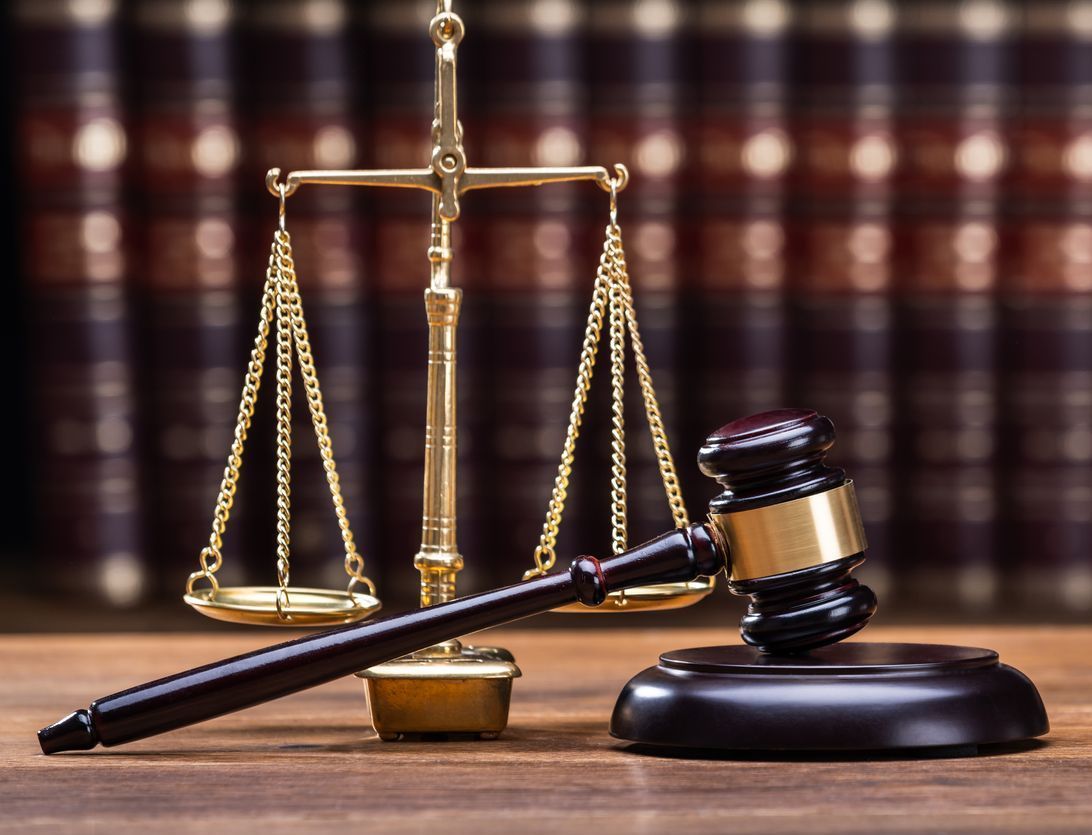 Wooden Gavel With Golden Scale On Table