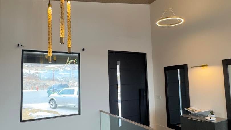 Modern lobby with framed wall art, pendant lights, a ring ceiling light, and a reception desk.