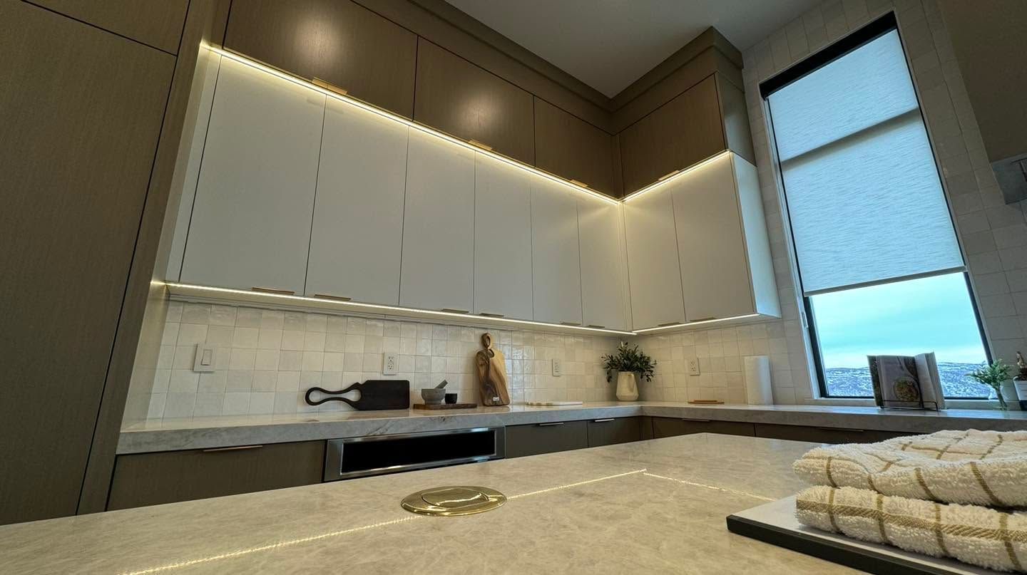 Modern kitchen with white cabinets, black countertops, and a large window by the sink