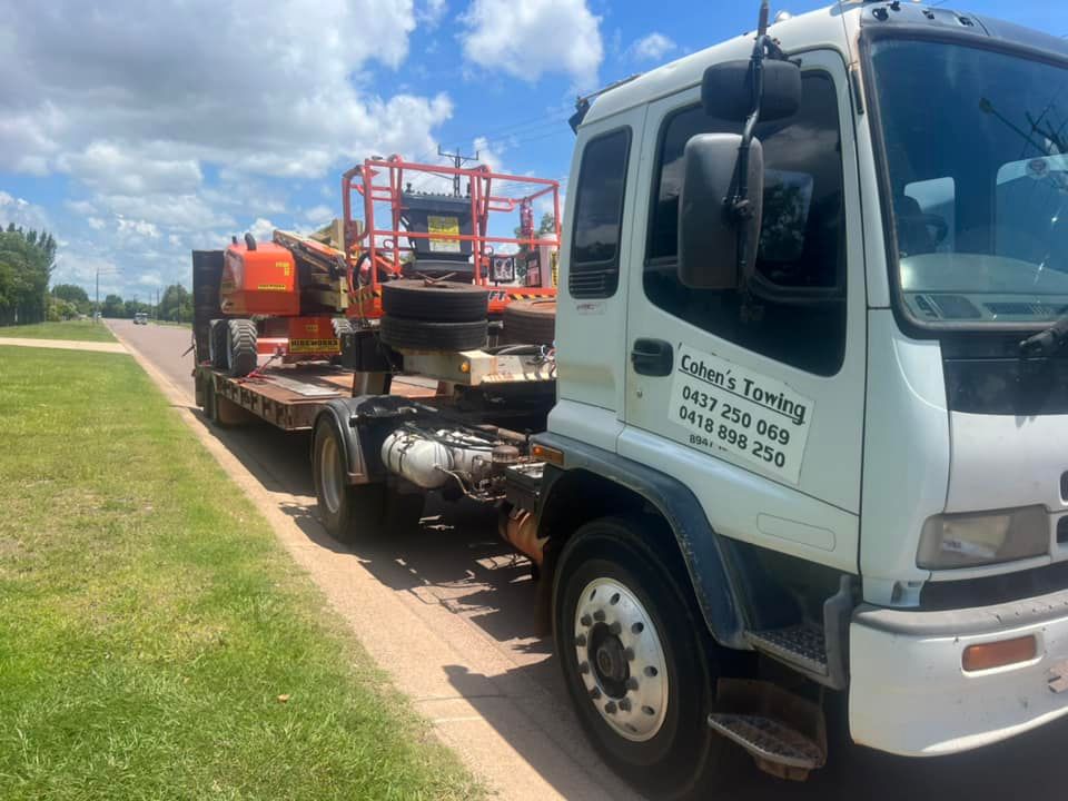 A Tow Truck is Towing a Trailer With a Lift on It — Cohen’s Towing & 4WD Recoveries In Katherine, NT