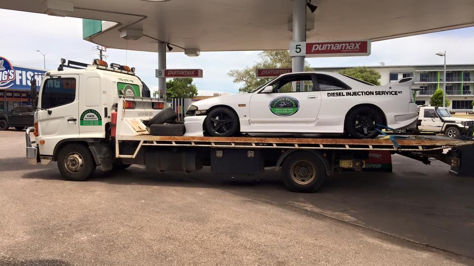 A Car is Being Towed by a Tow Truck at a Gas Station — Cohen’s Towing & 4WD Recoveries In Winnellie, NT