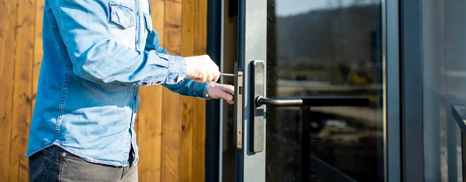 Person in blue shirt opening a door.