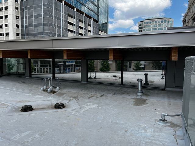 a rooftop with a lot of windows and a building in the background