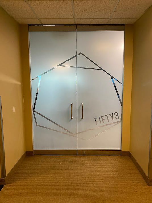 A hallway with a glass door that says fifty3 on it