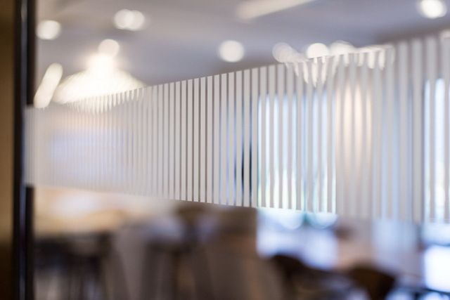 A blurry picture of a room with a striped glass wall.