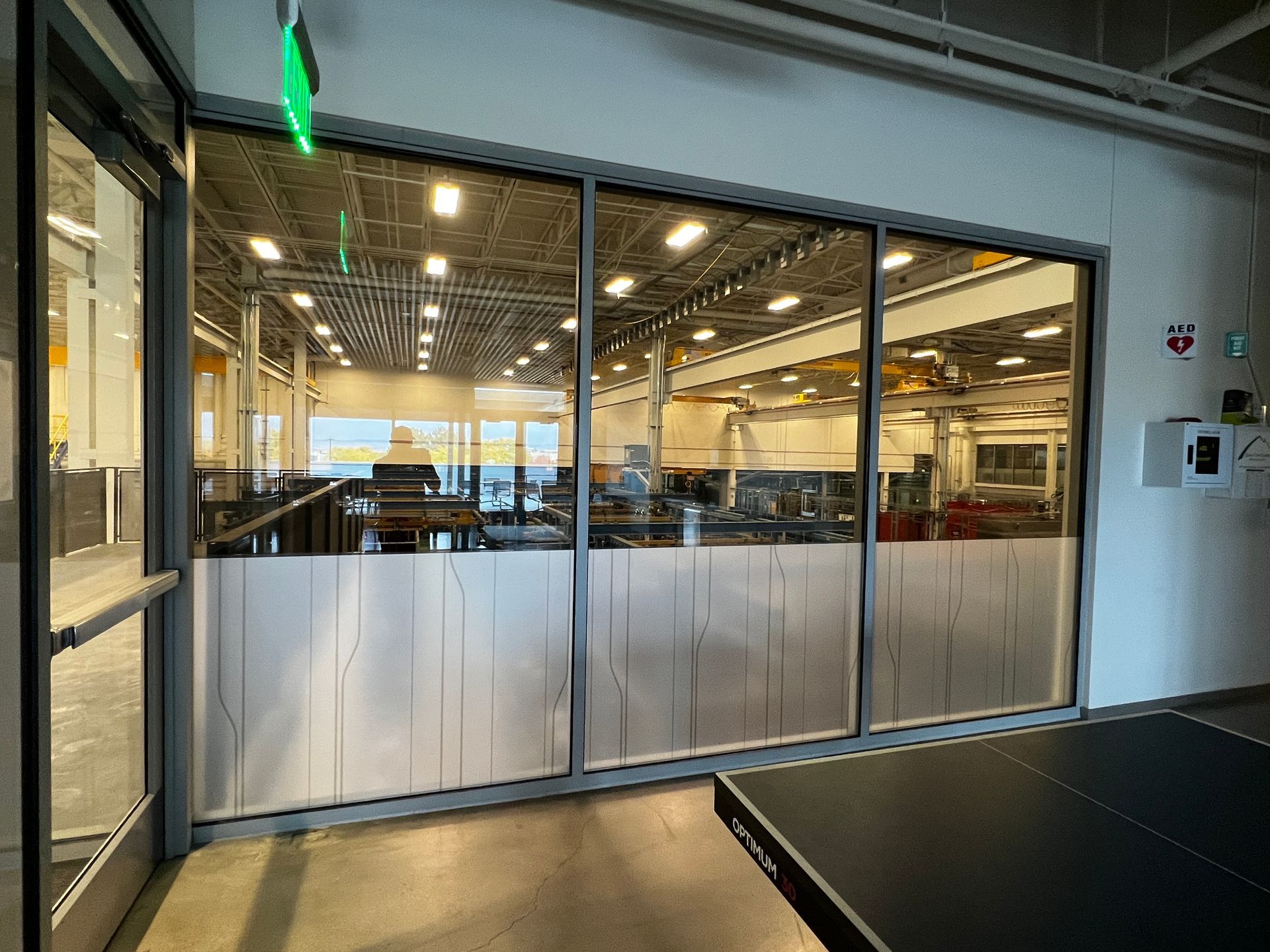 A room with a ping pong table and a large window.