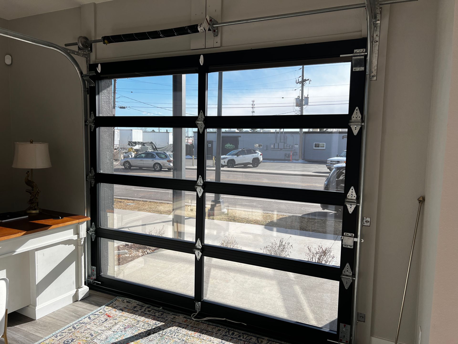 A garage door with a lot of windows is open in a room.