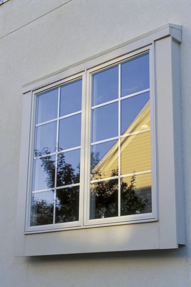 A window on the side of a building with a blue sky behind it