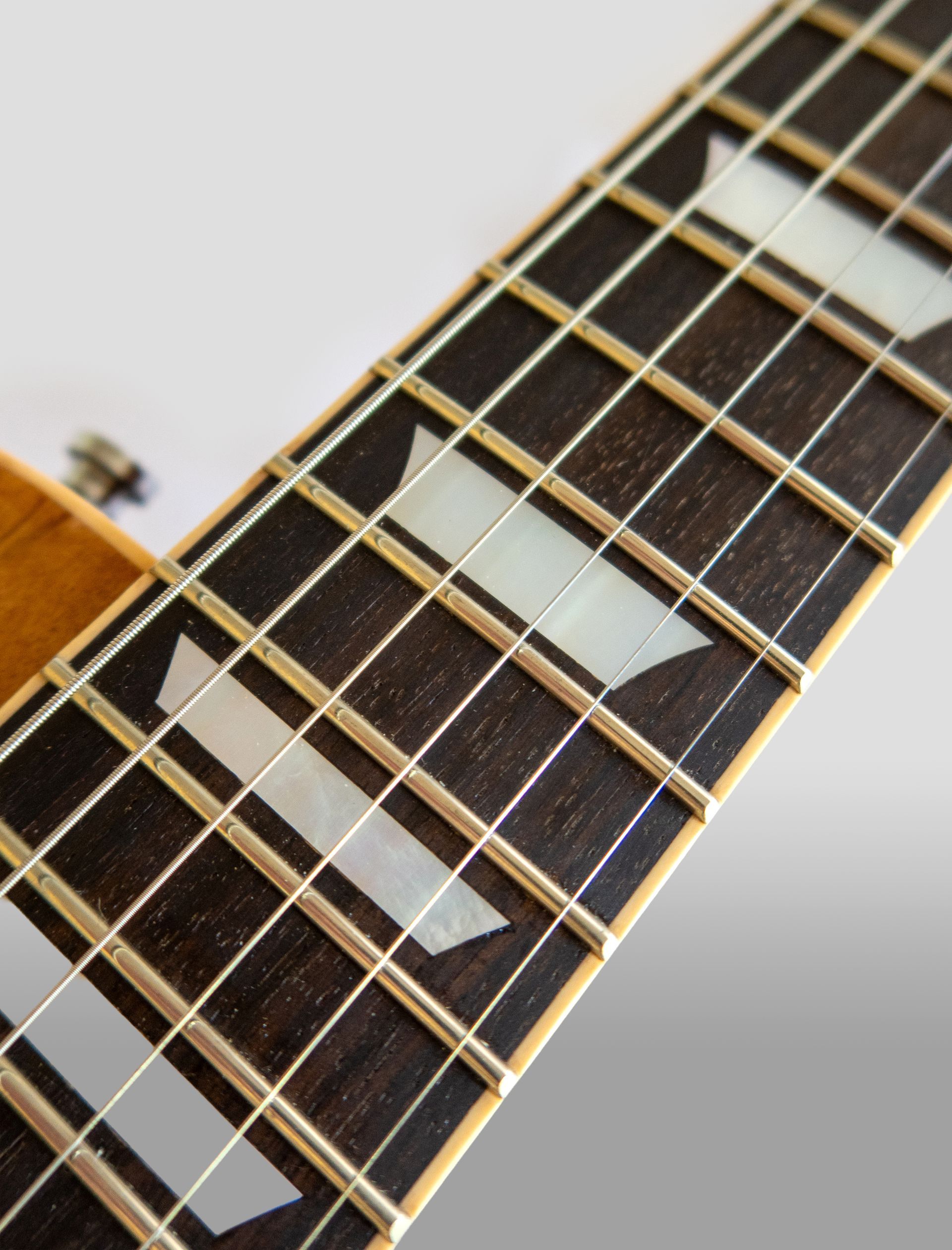 Een close-up van de hals met MOP inleg van een elektrische gitaar