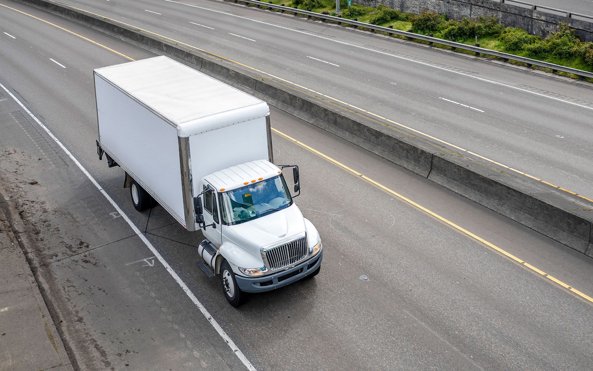 A white truck is driving down a highway.