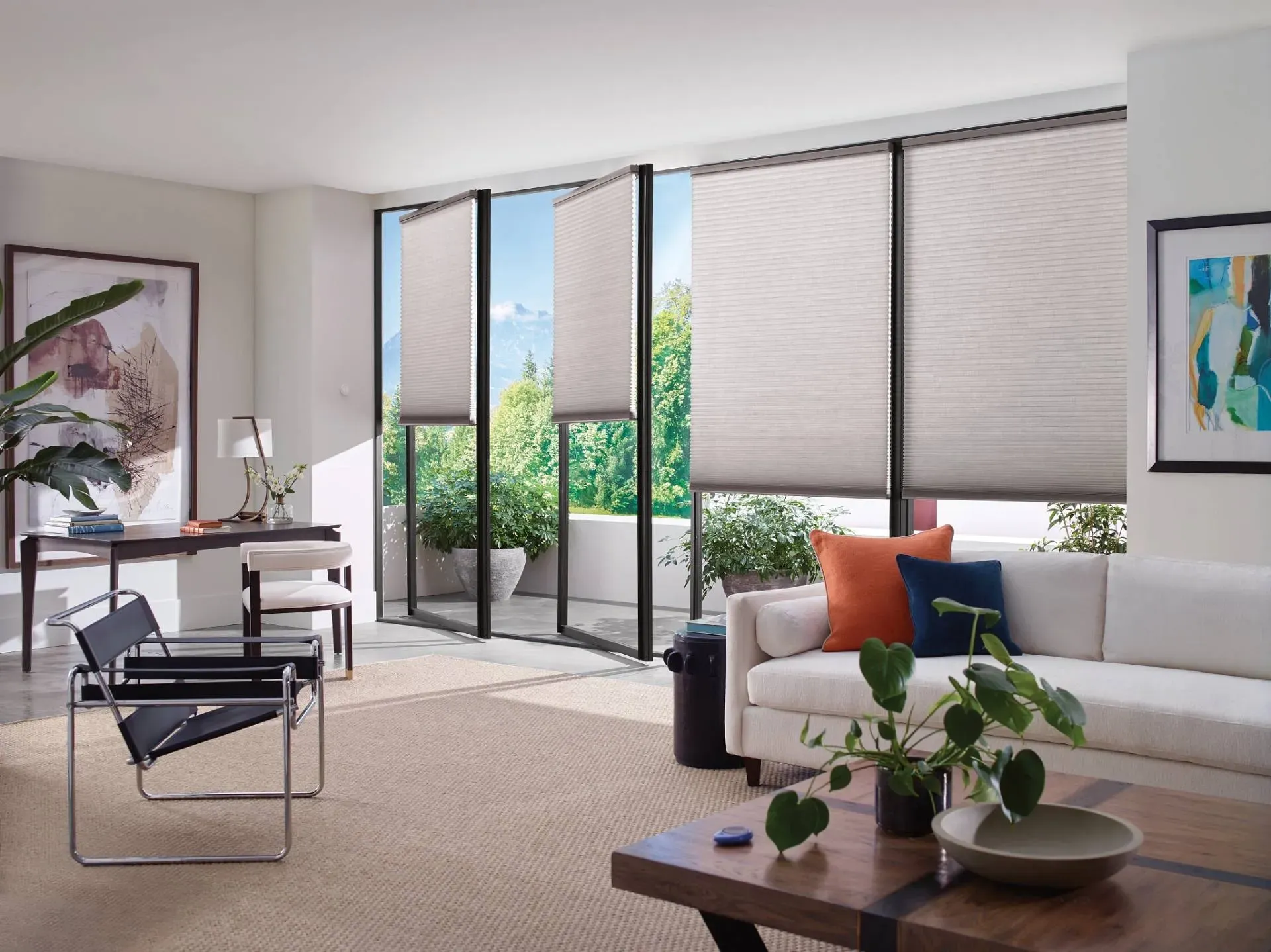 Living room with large windows, neutral blinds, sofa with colorful pillows, and modern furniture.