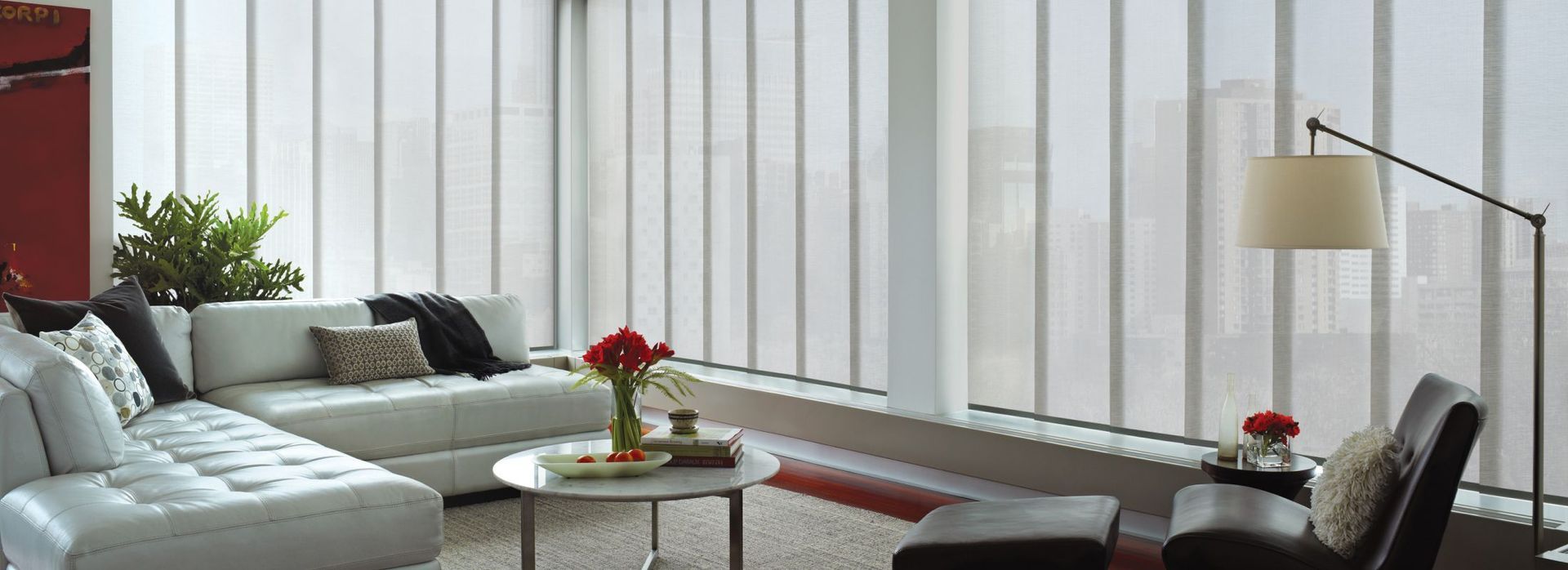 Modern living room with white sofa, vertical blinds, and a floor lamp.