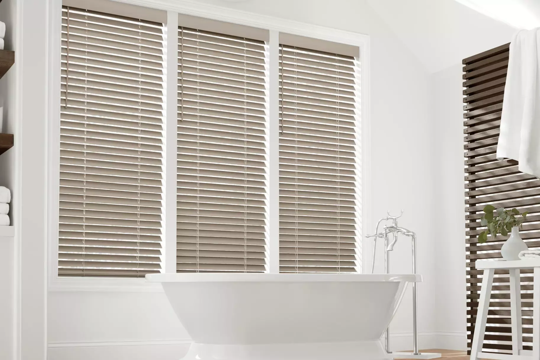 Bathroom with wooden blinds over a bathtub. The blinds are light brown.