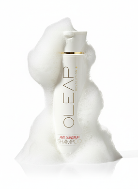 Flacone bianco di prodotti skincare OLEAP con tappo dorato, circondato da schiuma bianca su sfondo bianco