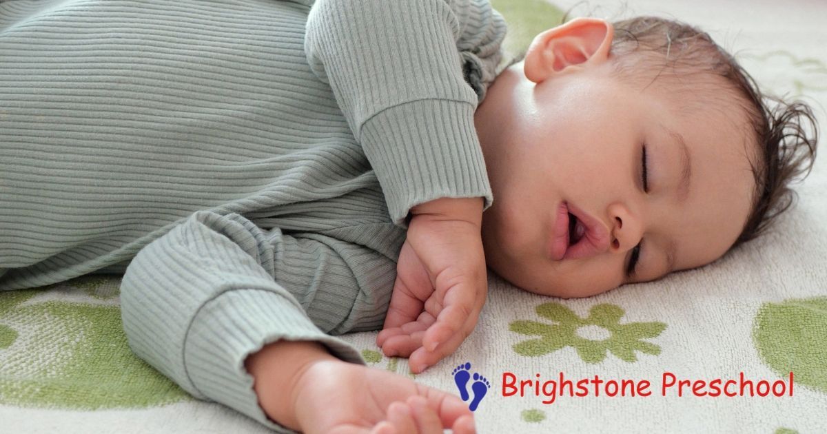 Sleeping baby on a soft white blanket beside the Brightstone Preschool logo