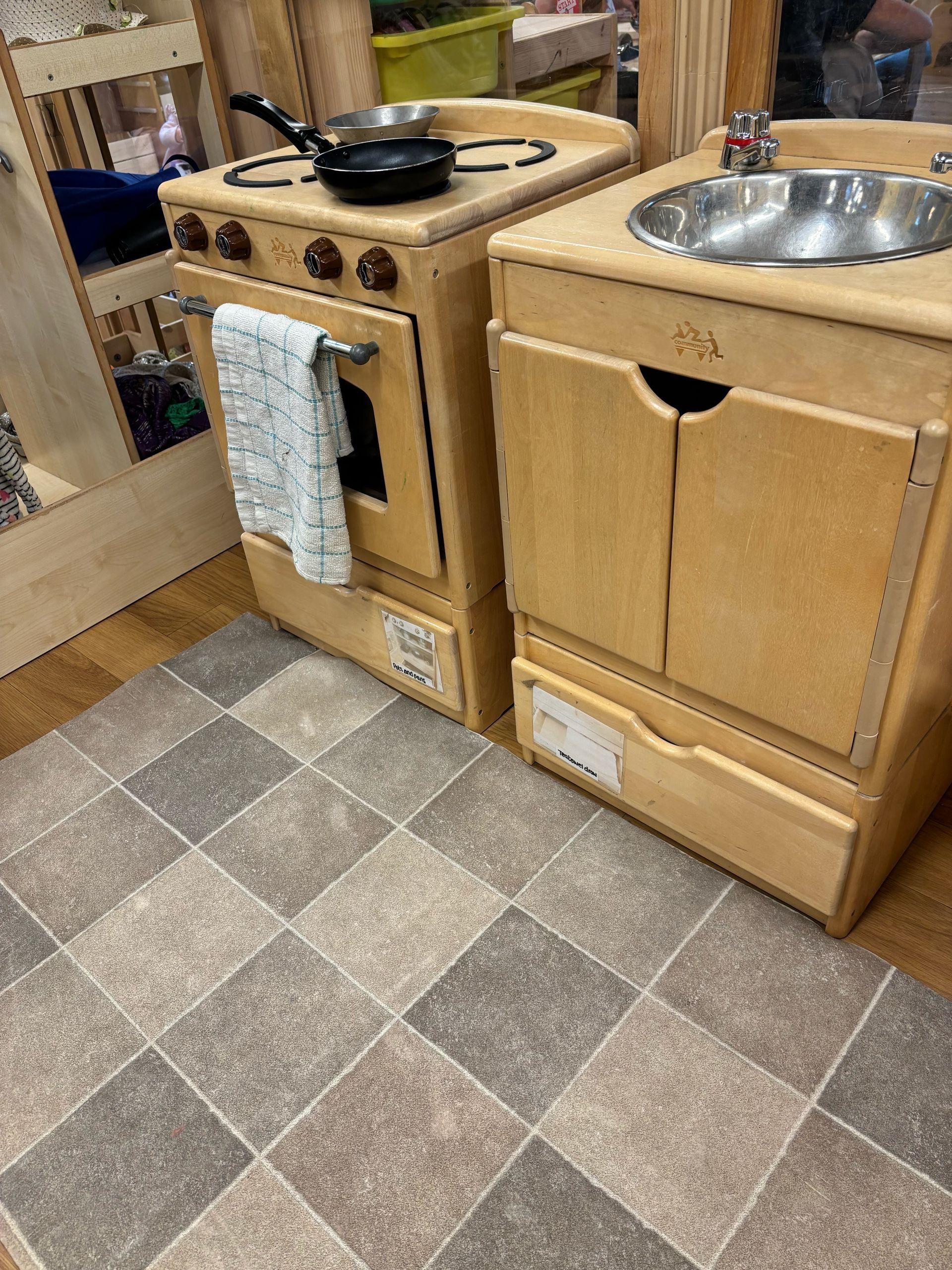 A wooden play kitchen with a sink and stove.