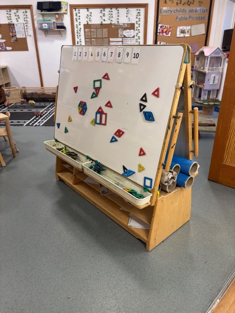 Wooden easel with magnetic shapes; educational classroom.