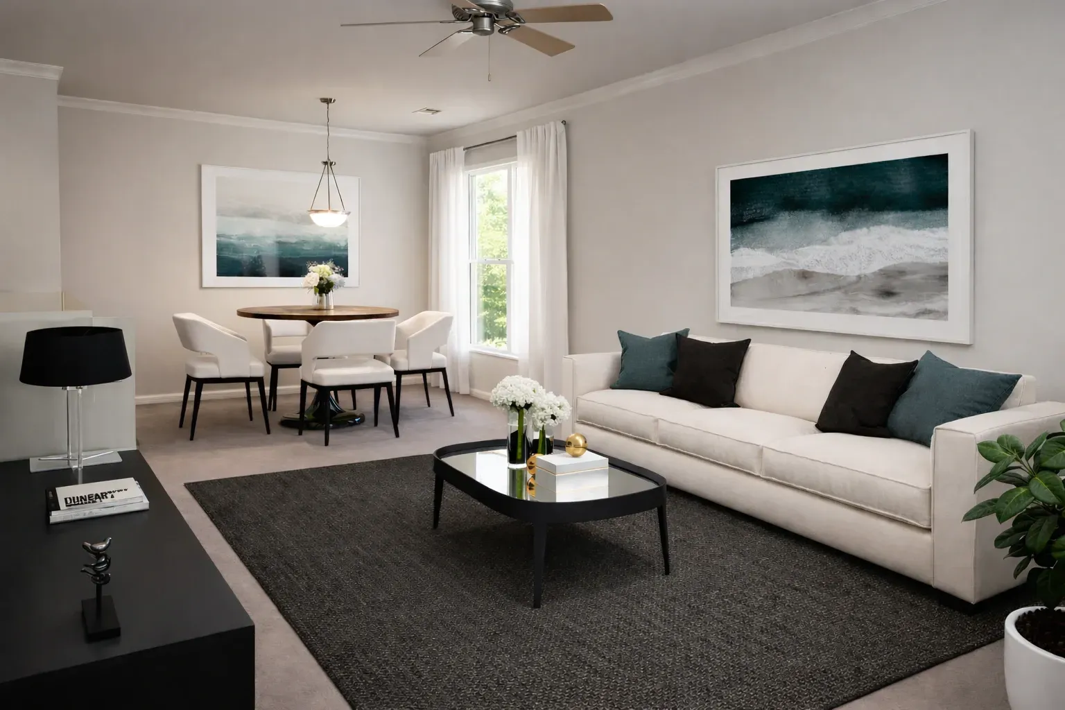 Bright and airy living and dining area with a white sofa, dining table, and large artwork.