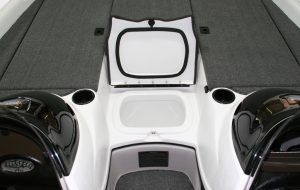 Boat interior with open storage compartment and cup holders.
