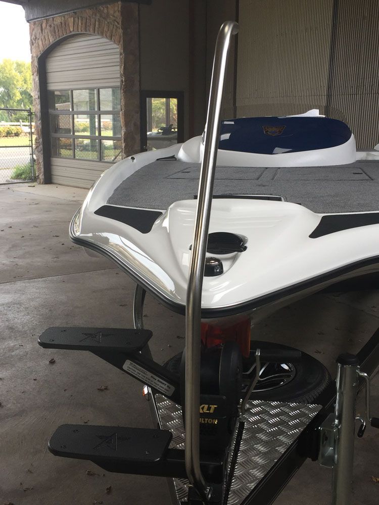 Boat on a trailer with a boarding ladder and a white and blue exterior.