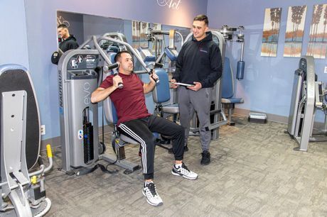 A Man is Sitting on a Machine in a Gym while a Man Stands Behind him | Uniontown, OH | My Personal Trainer