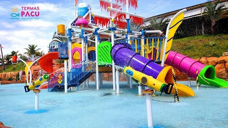 Vista aérea de uma pessoa flutuando em uma piscina natural de cor turquesa brilhante, cercada por vegetação tropical exuberante.