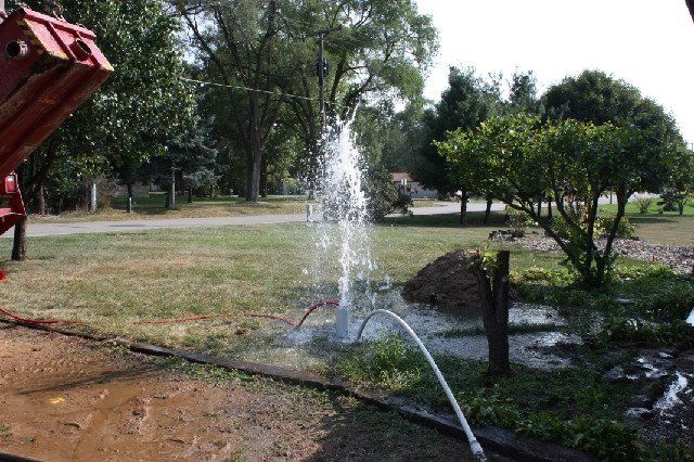 Outdoor well pump with connected PVC piping.
