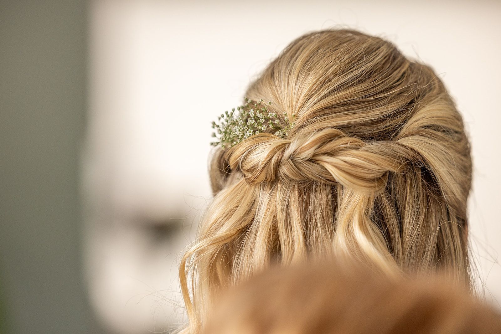 Blond haar, gevlochten met kleine groene takjes.