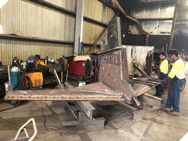 A Man is Welding a Piece of Metal in a Factory — North Queensland Hard Facing (NQHF) In Fredericksfield, QLD