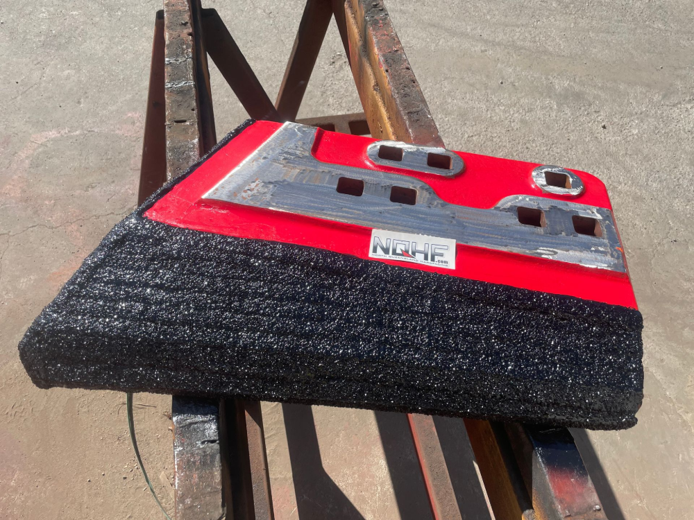 Red and silver object with black textured bottom, “NQHF” label. — North Queensland Hard Facing (NQHF) In Fredericksfield, QLD