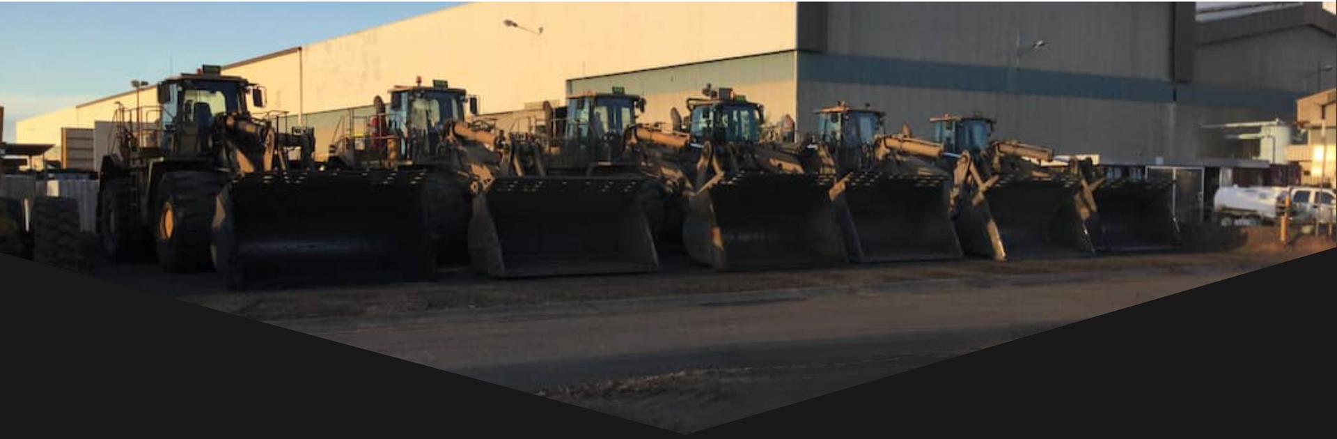 Row of Bulldozers Are Parked in Front of a Building — North Queensland Hard Facing (NQHF) In Fredericksfield, QLD