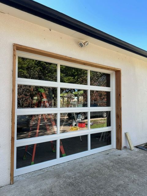 White paneled garage door with clear glass panels framed in wood.